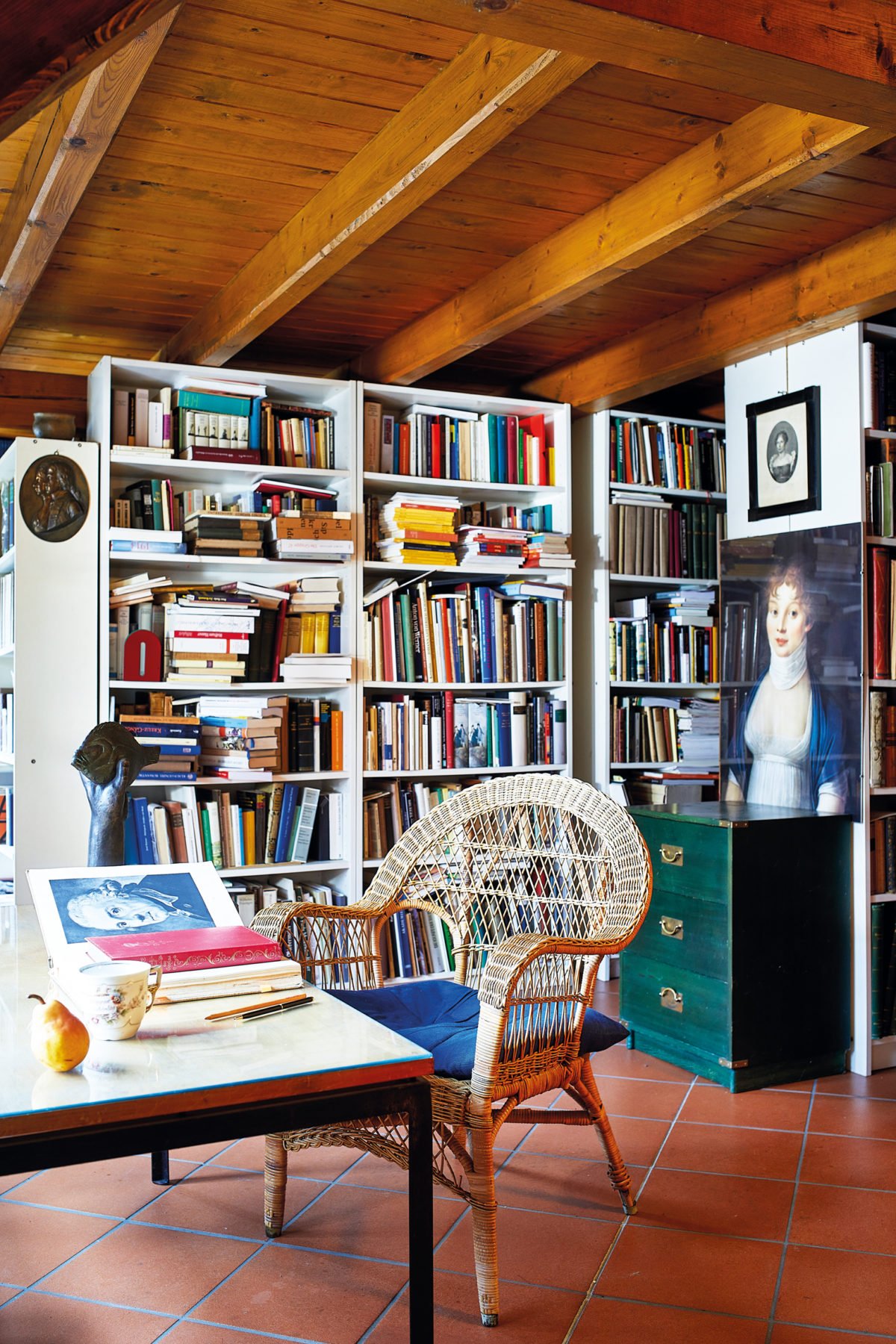 Blick in einen Arbeitsraum mit einem Schreibtisch und großem Bücherregal