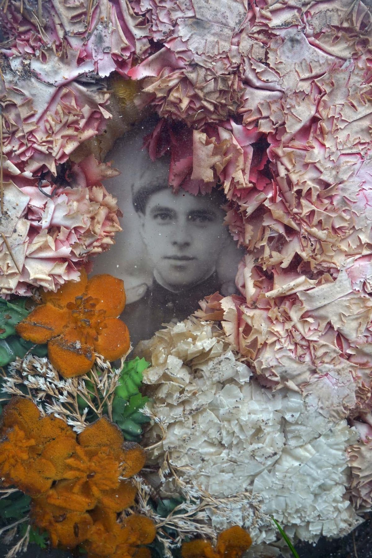 Foto eines sowjetischen Soldaten, dass umringt ist von platt gedrückten Blumen