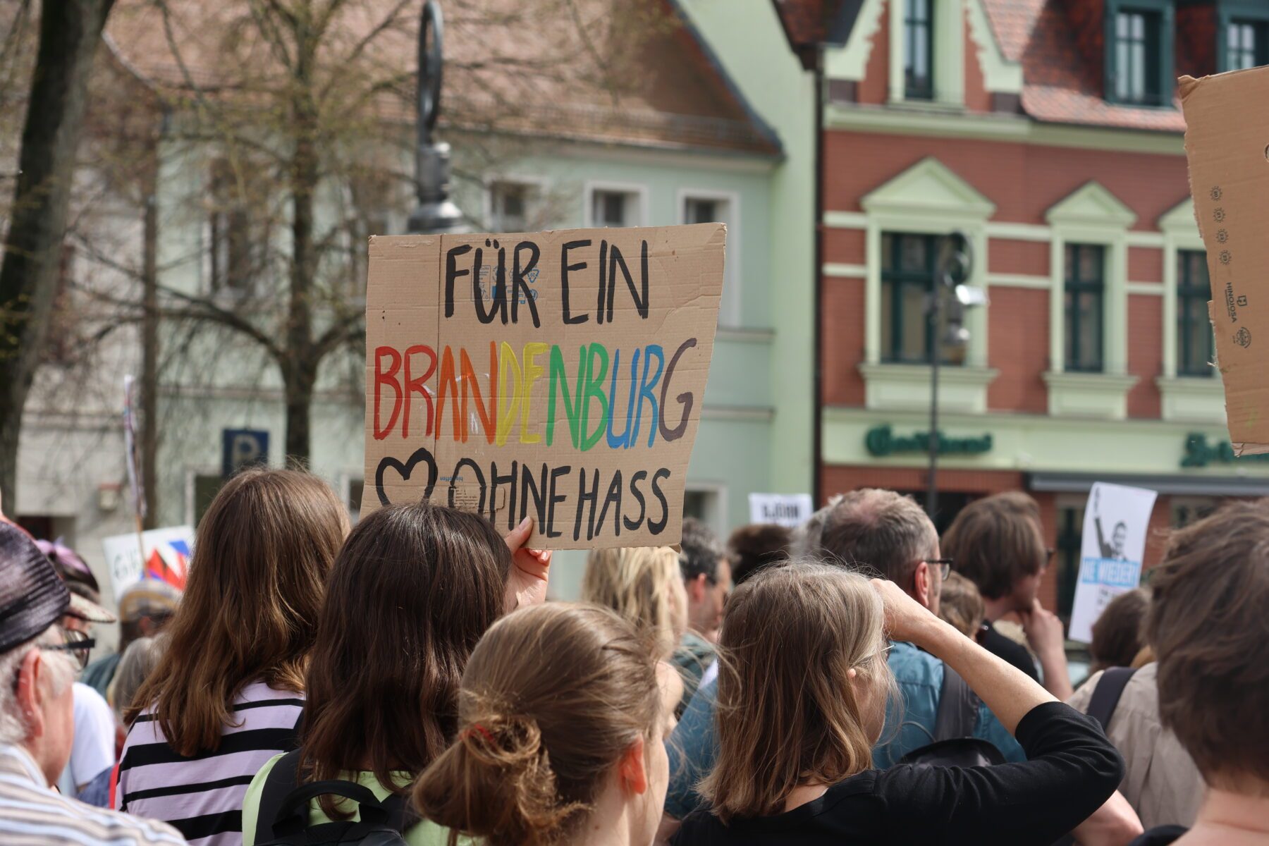 Eine Gruppe Menschen, die ein Schild mit der Aufschrift Für ein Brandenburg ohne Hass hochhält.