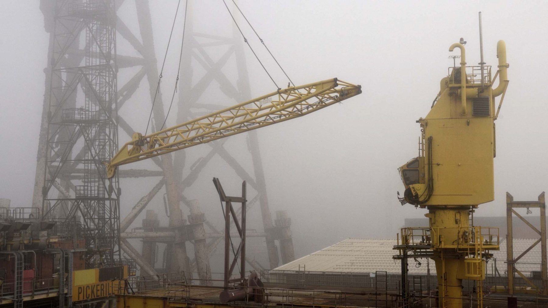 Kräne und Industrieanlagen im Nebel