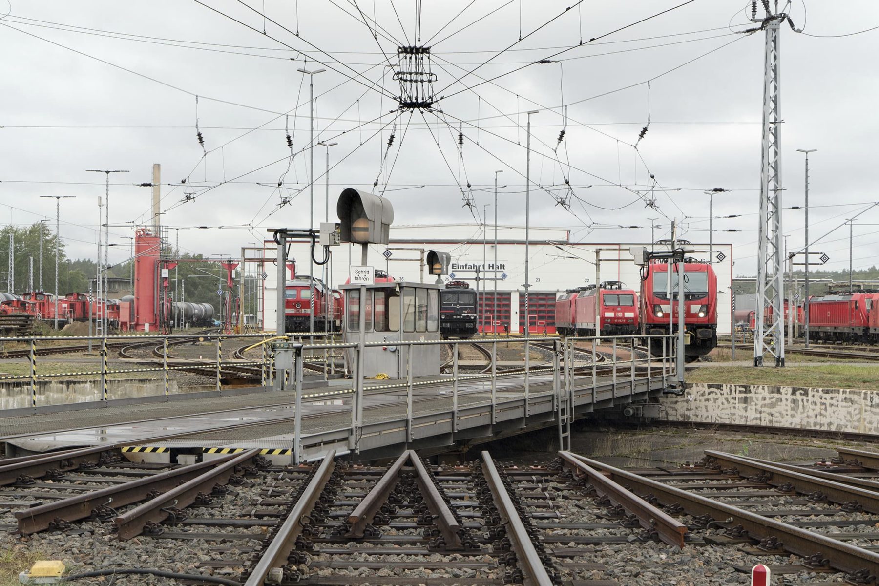Drehscheibe auf einem Bahnbetriebsgelände, im Hintergrund stehen verschiedene Lokomotive
