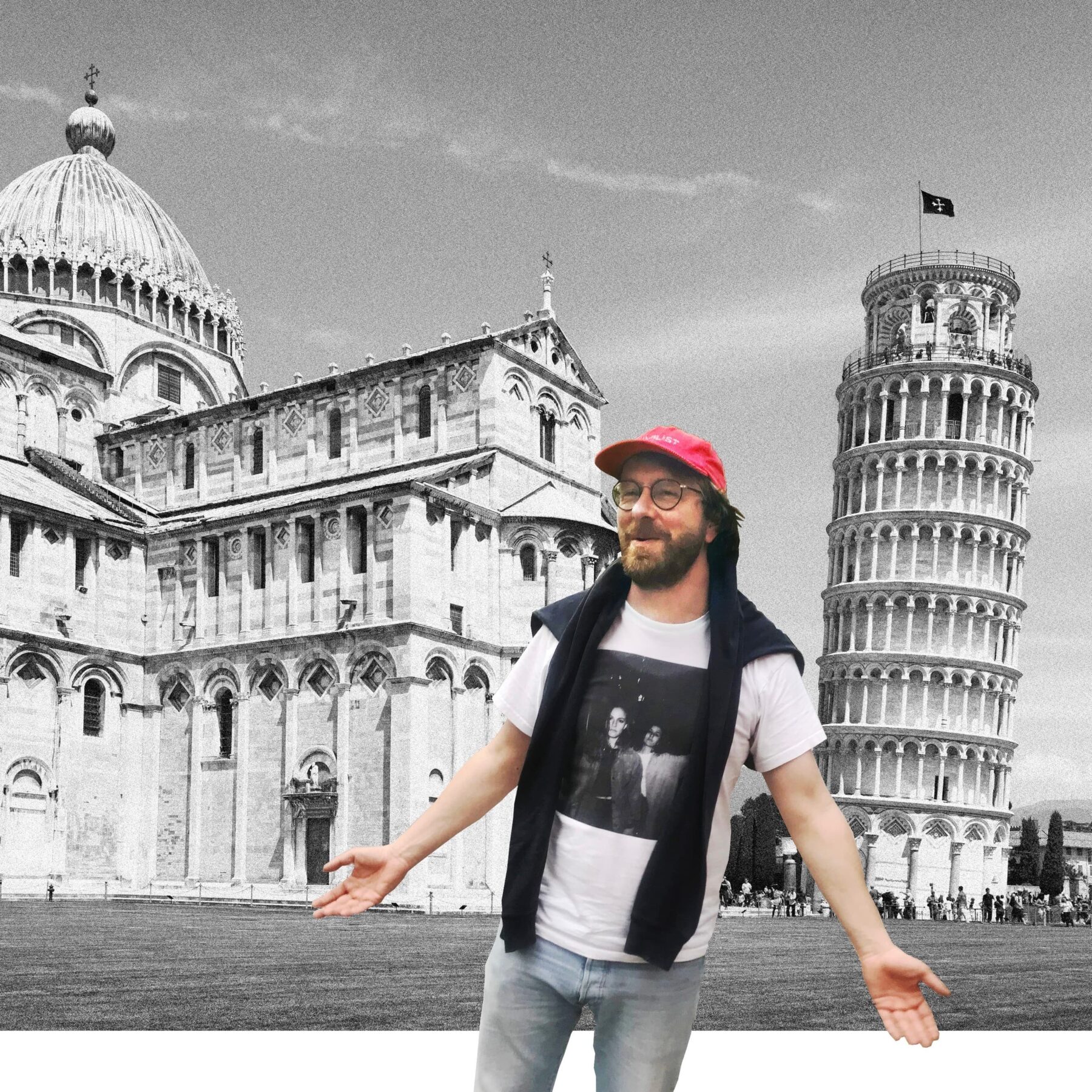Ein Mann steht mit offenen Armen vor dem Turm zu Pisa und einer Kirche. Er trägt ein rotes Cap.