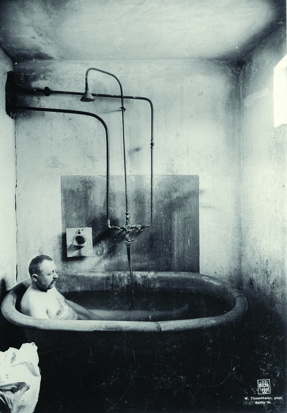 schwarz-weiß Bild, Mann sitzt in einer Badewannde