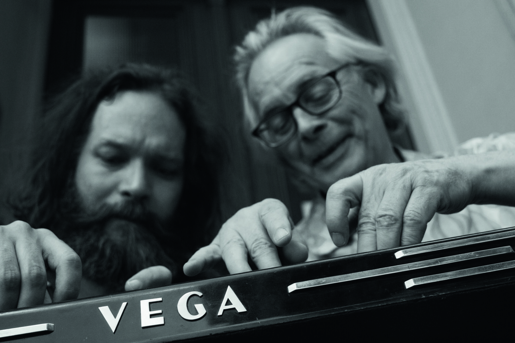 Zwei Personen spielen auf einem Musikinstrument der Marke Vega.