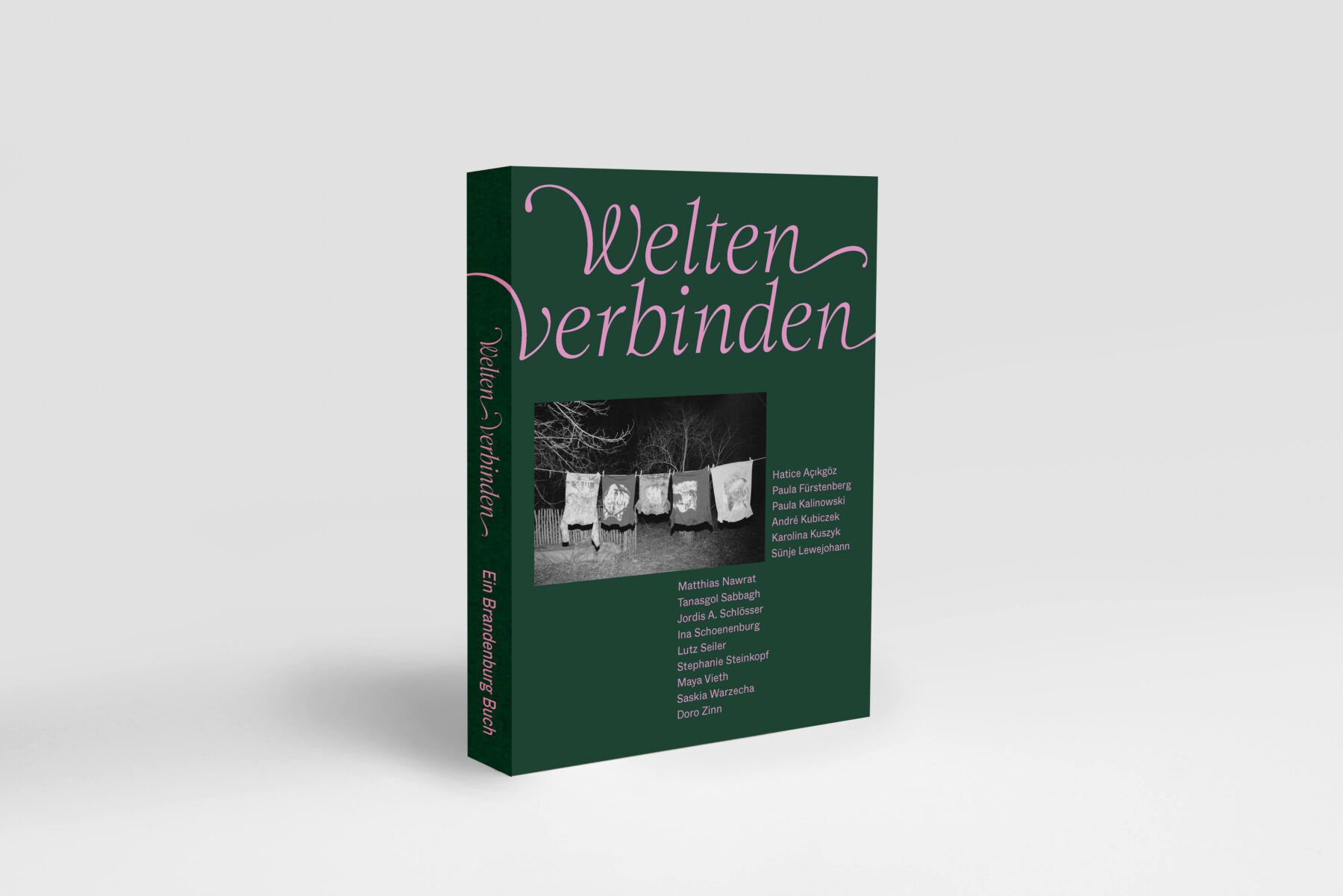 Grünes Buch mit einem schwarz-weißen Bild darauf, rosafarbene Schrift mit dem Text "Welten verbinden".