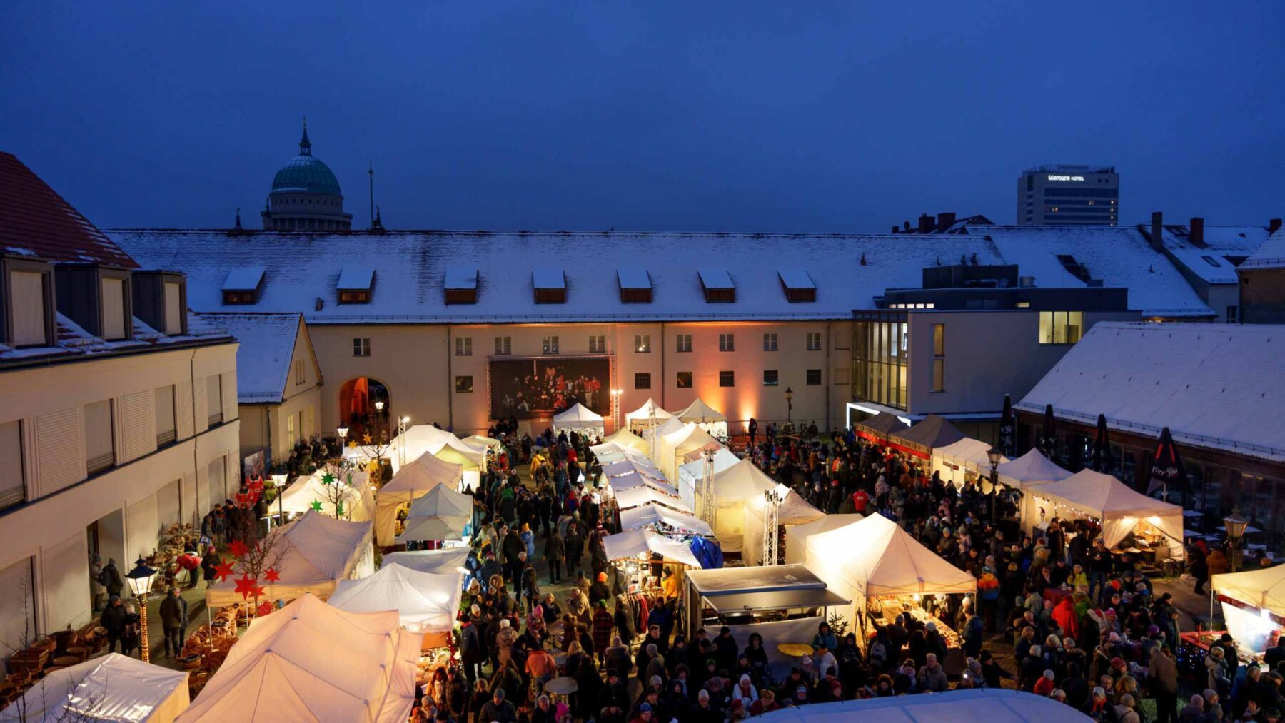 Blick auf den Kutschstallhof mit leuchtenden Buden des polnischen Sternenmarktes